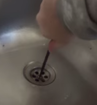 Берем отвертку и выкручиваем фиксирующий болт из фильтра слива раковины